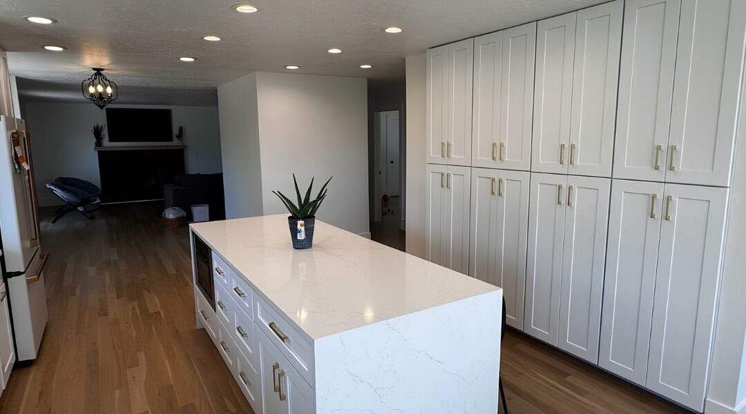 Luxury high-capacity gourmet kitchen remodel in Taylorsville UT featuring custom inset white oak cabinetry, a massive central quartz island, and smart professional appliances.
